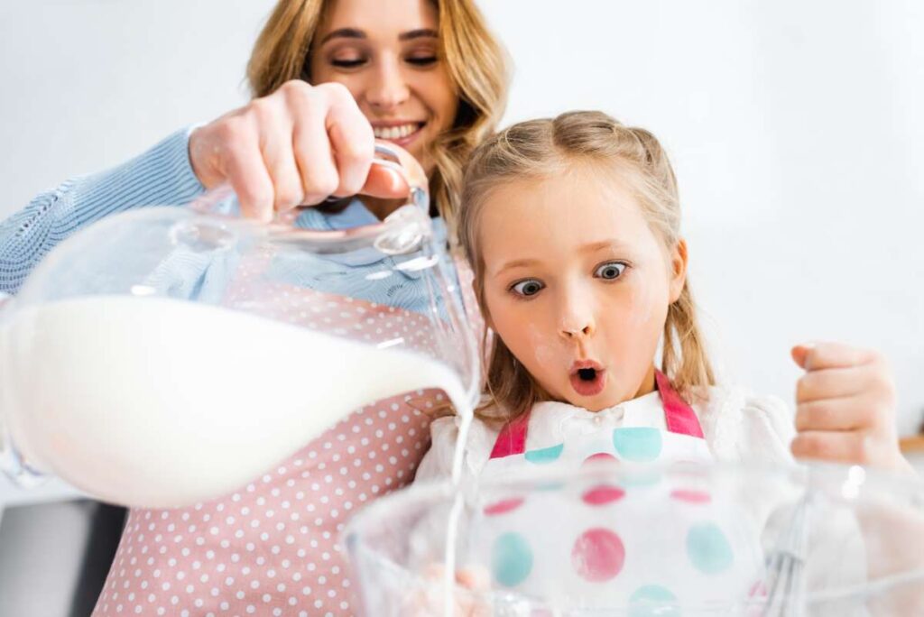 mamička s dcérou lejú mlieko do misky
