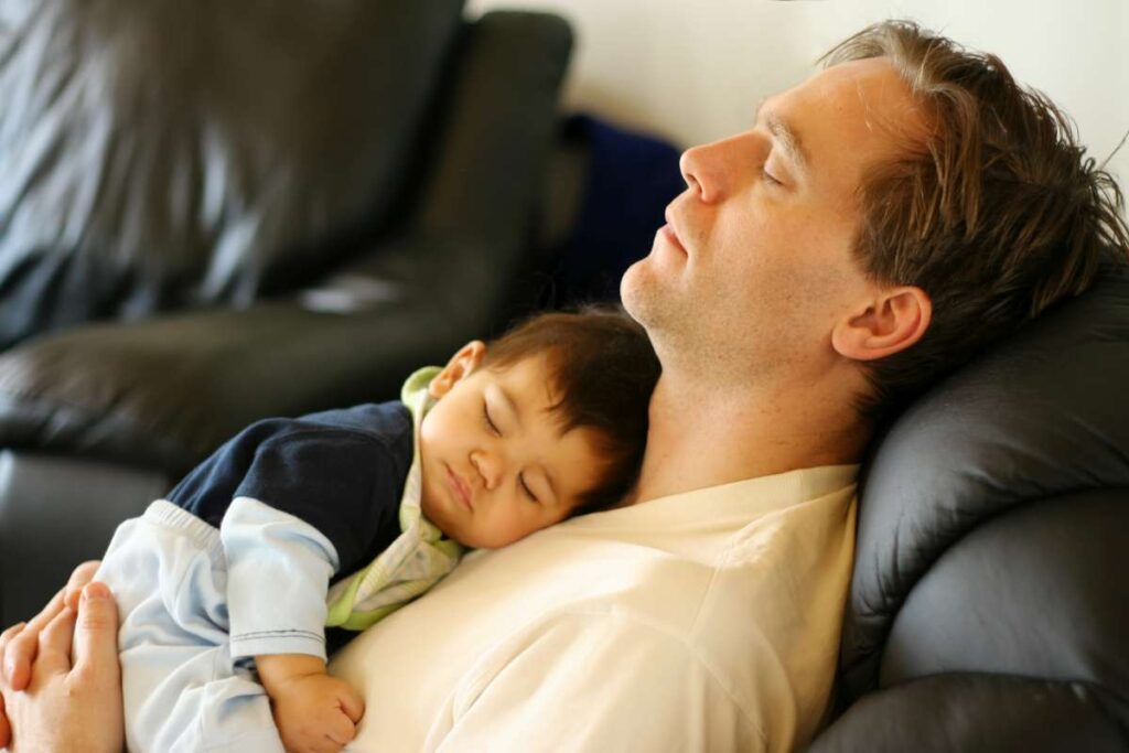 spiaci otecko s bábätkom na hrudi