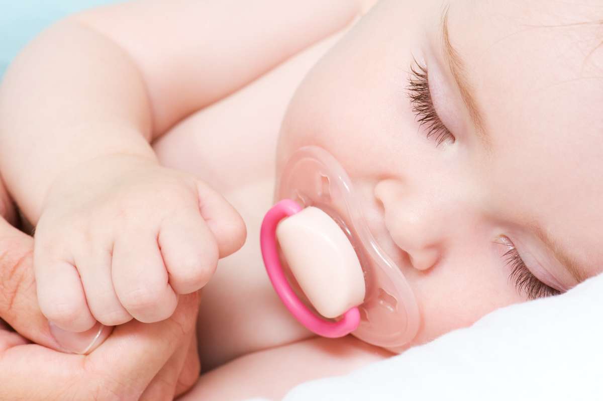 spiace bábätko s cumlíkom v ústach
