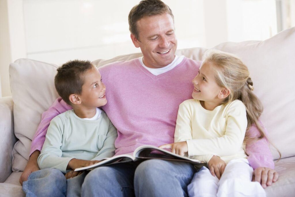 otecko s chlapcom a dievčaťom čítajú knihu